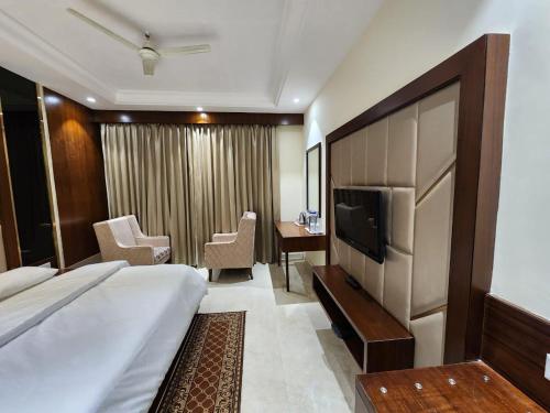 a hotel room with a large bed and a television at Hotel sun park inn in Dehradun