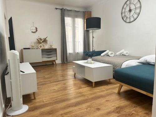 a living room with a bed and a table with a couch at Appartement Citadelle in Bonifacio