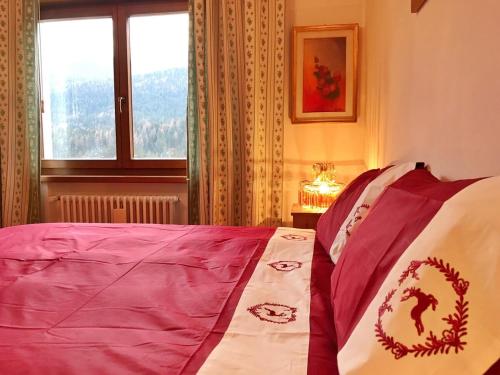 a bedroom with a bed with a red and white blanket at Ciasa Marian 10 minutes from Cortina with free parking! in Borca di Cadore