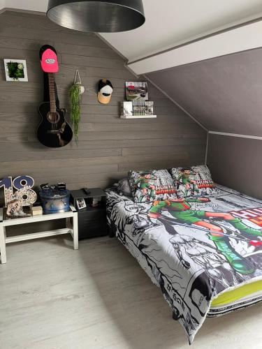 - une chambre avec un lit et une guitare dans l'établissement Maison proche du circuit des 24h du Mans, à Saint-Mars-dʼOutillé