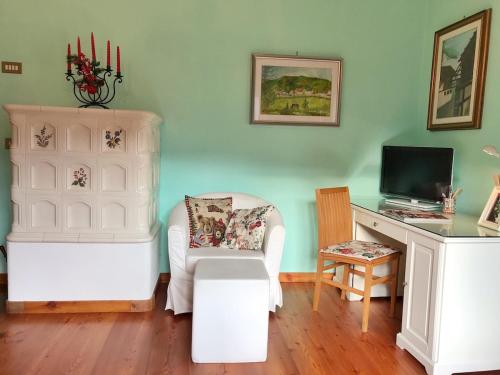 a room with a chair and a desk with a television at Ciasa Marian 10 minutes from Cortina with free parking! in Borca di Cadore