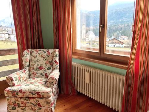 a chair sitting in a room with a window at Ciasa Marian 10 minutes from Cortina with free parking! in Borca di Cadore