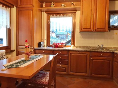 a kitchen with wooden cabinets and a table and a window at Ciasa Marian 10 minutes from Cortina with free parking! in Borca di Cadore