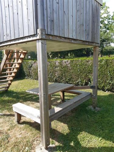 une plate-forme en bois avec un banc dans l'herbe dans l'établissement Camping Onlycamp Les Grenettes, à La Varenne
