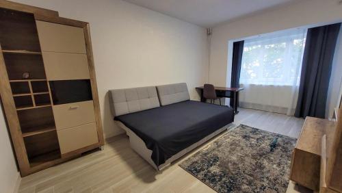a bedroom with a bed and a desk and a window at Modern Studio Craiova in Craiova