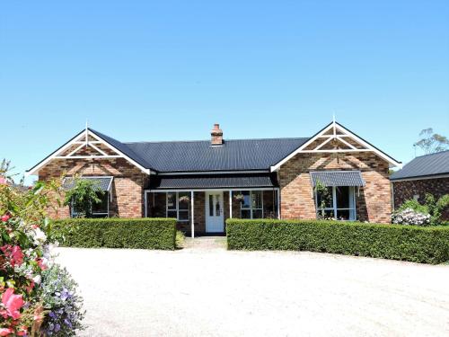 a brick house with a black roof at Hazelcreek Cottages in Exeter