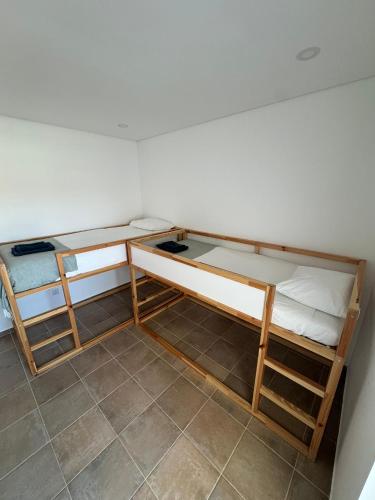two bunk beds in a room with a tile floor at TALAFA Beach House - Almograve in Almograve
