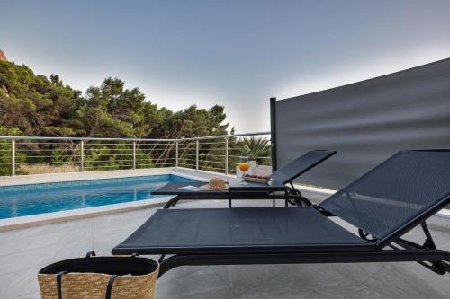 a table and chairs sitting next to a swimming pool at Villa la Perla in Baška Voda