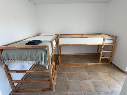 a small room with two bunk beds and a tile floor at TALAFA Beach House - Almograve in Almograve