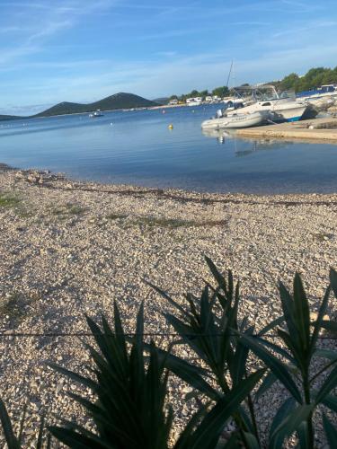 a view of a beach with boats in the water at Serenity house, cozy familly place, free parking, seaside, in Dalmacia, Drage, Kamp Maslina in Drage
