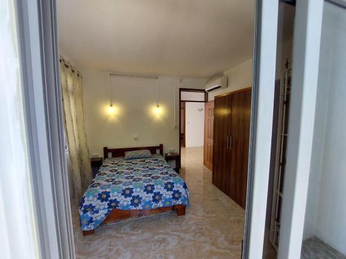 a bedroom with a bed with a blue and white comforter at Peaceful Calodyne Stay with Pool in Calodyne