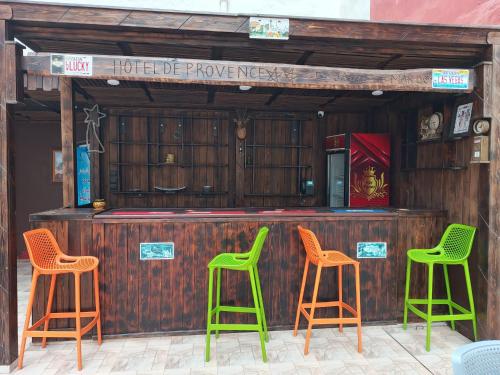 a bar with four green and orange stools at Hotel De Provence in El Jadida