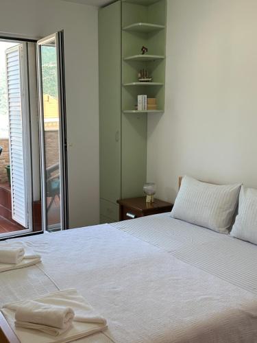 a bedroom with a large white bed and a window at Apartman sa pogledom na more Budva in Budva