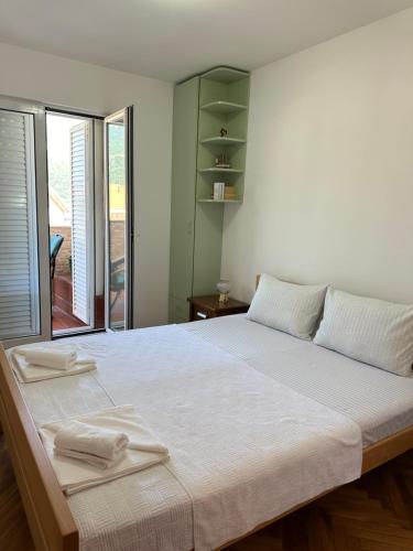 a bedroom with a large bed with two towels on it at Apartman sa pogledom na more Budva in Budva
