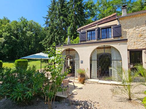 a house with an umbrella and a patio at Font Neuve in Souillac