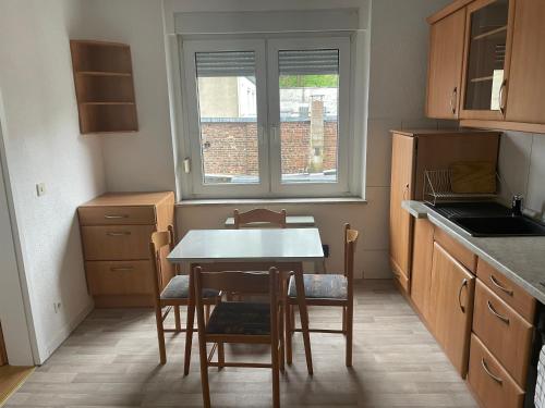 una cucina con tavolo, sedie e finestra di Monteurwohnung Dajka a Solingen