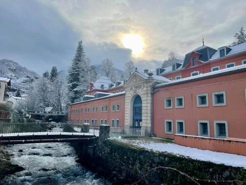 a bridge over a river in a city with buildings at Maison de charme au cœur d'Ax-Les-Thermes in Ax-les-Thermes