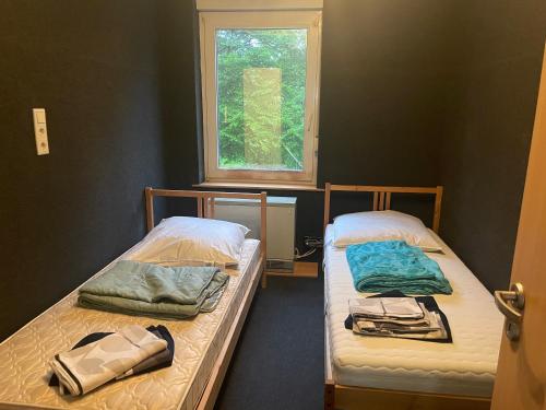 due letti in una stanza con finestra di Monteurwohnung Dajka a Solingen