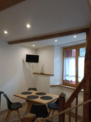 a room with a table and chairs and a window at Maison de charme au cœur d'Ax-Les-Thermes in Ax-les-Thermes