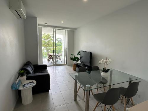 a living room with a glass table and a couch at 2bedroom 2bath in Garden city in Brisbane