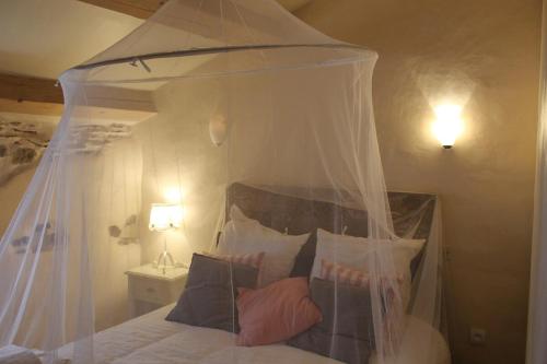 - une chambre avec un lit à baldaquin et des oreillers dans l'établissement The Little Pink House Eau De Thermale Avène, à Le Bousquet-dʼOrb