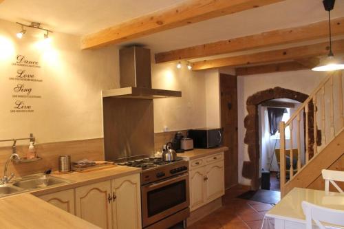 une cuisine avec une cuisinière et un évier dans l'établissement The Little Pink House Eau De Thermale Avène, à Le Bousquet-dʼOrb