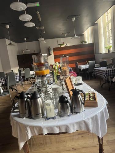 a table with utensils and pitchers on top at B&B Maria Hart in Weert