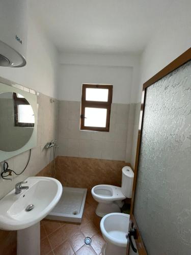 a bathroom with a sink and a toilet and a window at B Bibaj in Durrës
