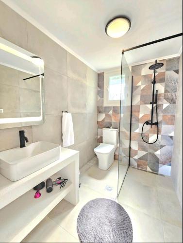 a bathroom with a sink and a toilet and a shower at OLiVE HOUSE in Vathi, Ithaka