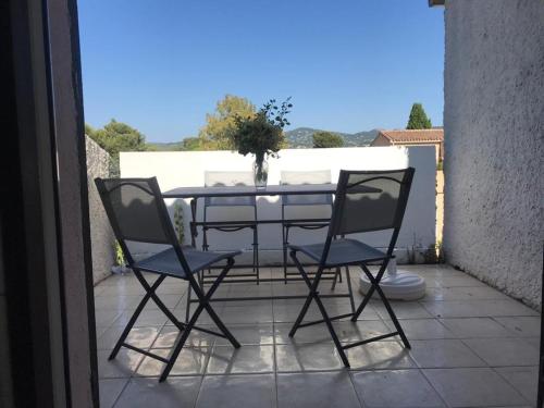 une table et deux chaises sur une terrasse dans l'établissement Les Lavandes, à Saint-Cyr-sur-Mer