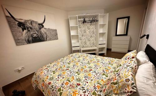 a bedroom with a bed with a picture of a cow on the wall at El Tujo in Obregon