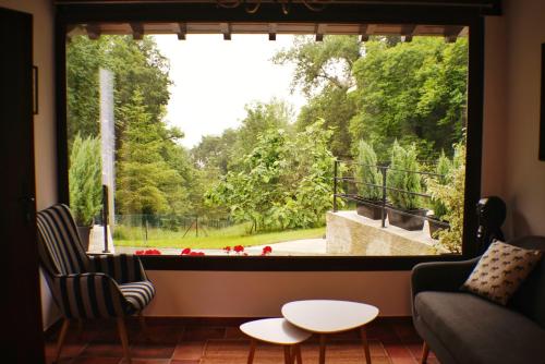 a living room with a large window looking out at a garden at El Tujo in Obregon