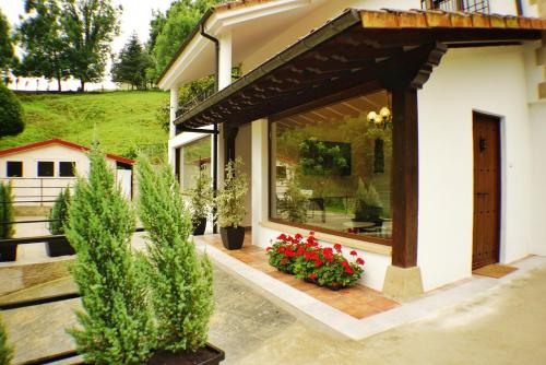 a house with a window with red flowers and plants at El Tujo in Obregon