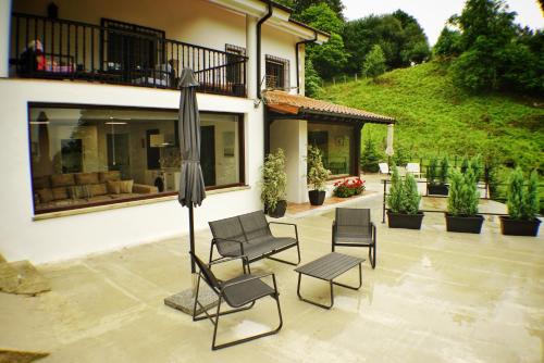 a patio with chairs and an umbrella in front of a house at El Tujo in Obregon