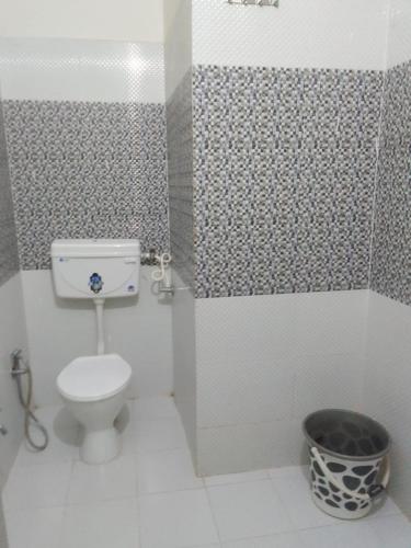 a bathroom with a toilet and a trash can at Hotel Shivam Grand Inn in Gorakhpur