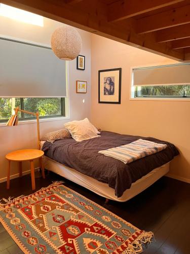 a bedroom with a bed and a window and a rug at Queens Drive in Oneroa