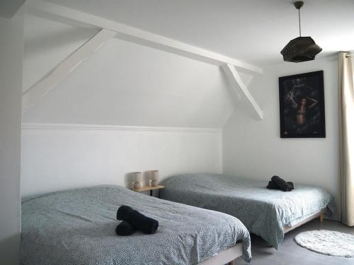 a bedroom with two beds with black towels on them at L'échappée Belle - La Grande Tribu in Rhinau