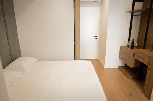 a bedroom with a white bed and a door at Vila Venezia in Shëngjin