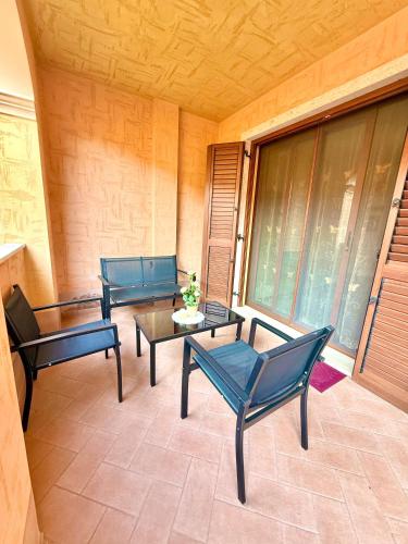 a patio with three chairs and a table and a window at Casa Selema in Donigala Fenughedu