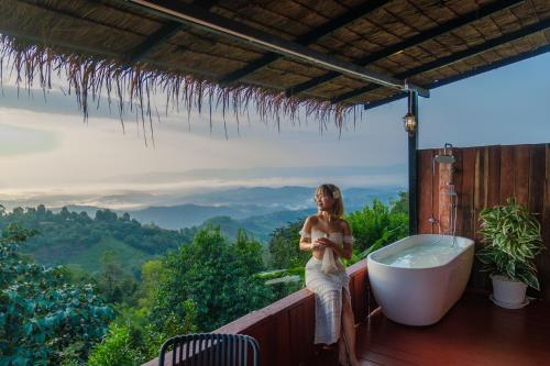 a woman sitting in a bath tub on a balcony at Maemon villa แม่มอญ วิลล่า in Ban Ri So