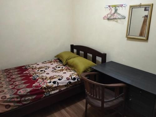 a bedroom with a bed with a table and a desk at Villa Ndelik Ijen in Kalibendo