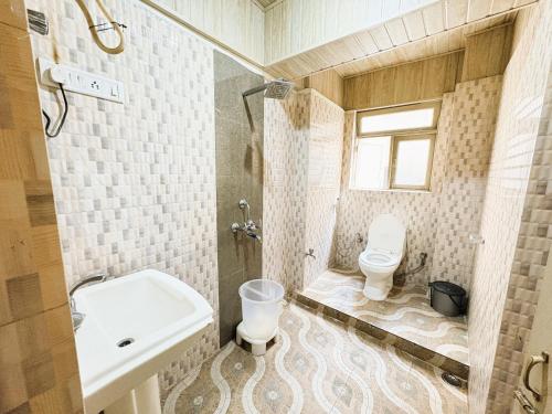 a bathroom with a sink and a toilet in it at Near Chauk Bazaar Marvel International & Restaurant HD Lama Rd in Darjeeling