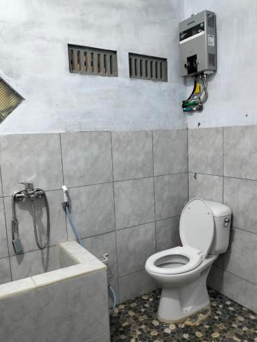 a bathroom with a toilet and a bath tub at Villa Ndelik Ijen in Kalibendo