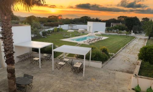 an outdoor patio with a table and chairs and a pool at Masseria Luci Grande in Scorrano
