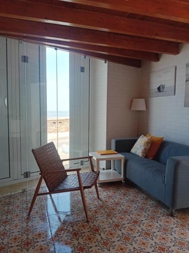 a living room with a blue couch and a chair at Casa do Tejo de Alcochete in Alcochete