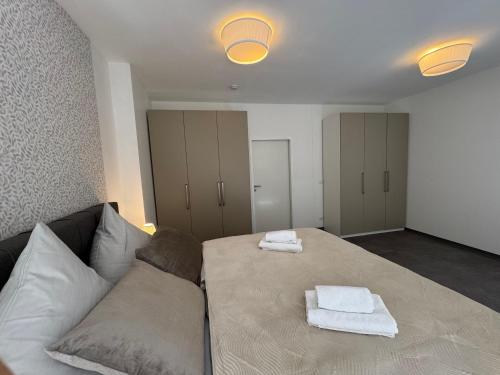 a room with a bed with towels on a couch at yusuite 2 in Hamburg