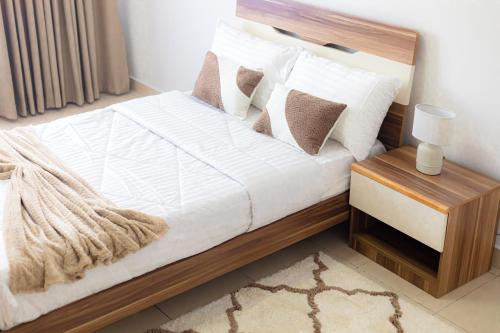 a bedroom with a bed with white sheets and pillows at POLO HEIGHTS-Sky Suites in Accra