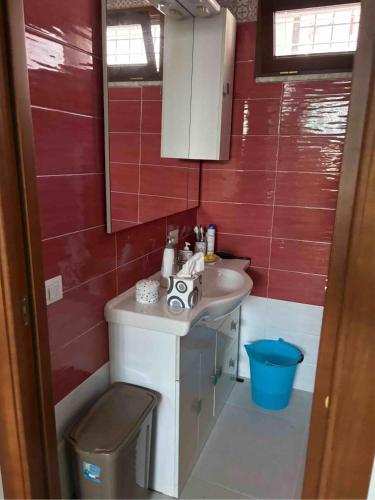 a bathroom with a sink and a red wall at Casagiusy in Vico Equense