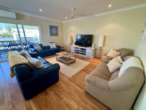 a living room with two couches and a tv at Open Plan Coastal Beauty in Patonga Beach in Patonga