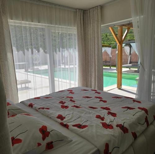 a bedroom with a bed with red flowers on it at Villa Aqua Vista in Mostar